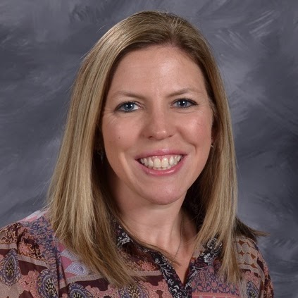 Smiling woman with long blond hair, wearing a patterned blouse