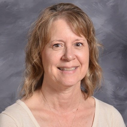 Professional portrait of a smiling woman with shoulder-length wavy hair