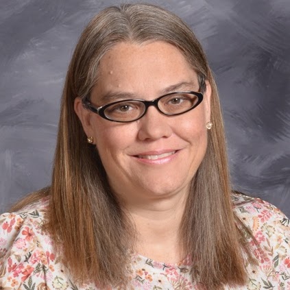 Headshot of a woman with long, straight hair and glasses, smiling warmly
