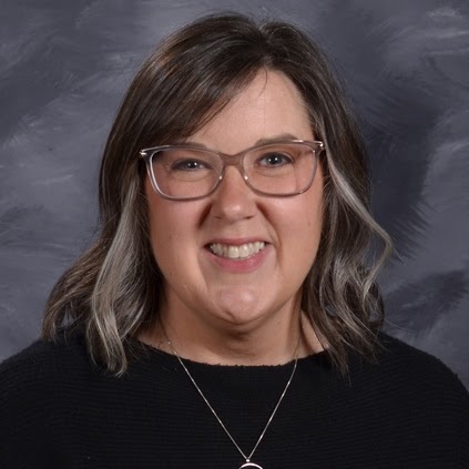 Smiling woman with brown hair and glasses